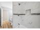 Renovated bath featuring tiled shower with niche and tiled accent trim at 1555 Newhope Rd, Spring Hill, FL 34606