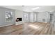 Bright open living room with a fireplace, lots of light, hardwood floors, and access to kitchen at 1555 Newhope Rd, Spring Hill, FL 34606