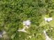 Areal view of a silver roofed home nestled amongst lush trees at 1562 Oakhurst Dr, Brooksville, FL 34601
