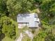 Aerial view of home featuring a silver metal roof and surrounded by lush trees at 1562 Oakhurst Dr, Brooksville, FL 34601