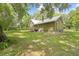 Spacious backyard featuring mature trees, lush greenery and a wooden deck at 1562 Oakhurst Dr, Brooksville, FL 34601