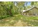Secluded home featuring an expansive backyard with mature trees and a wooden deck at 1562 Oakhurst Dr, Brooksville, FL 34601
