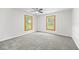 Large bedroom with neutral carpet, light walls, and dual windows with natural light at 1562 Oakhurst Dr, Brooksville, FL 34601