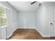 Bright bedroom featuring wood-look floors, light blue walls, and a large window with natural light at 1562 Oakhurst Dr, Brooksville, FL 34601
