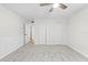 Bedroom with plush carpet, light walls, ceiling fan, and open doorway to hallway at 1562 Oakhurst Dr, Brooksville, FL 34601