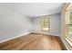 Bright bedroom featuring hardwood floors, neutral paint, and a window with a view of lush greenery at 1562 Oakhurst Dr, Brooksville, FL 34601