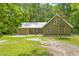 Exterior view of a charming home featuring a spacious yard and a silver metal roof at 1562 Oakhurst Dr, Brooksville, FL 34601