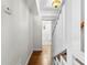Hallway with hardwood floors leading to a well-lit bathroom with stylish flooring at 1562 Oakhurst Dr, Brooksville, FL 34601