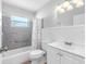 Bathroom featuring a sink, toilet, bathtub with gray tile surround, and a large mirror at 1701 38Th N St, St Petersburg, FL 33713