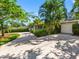 Home featuring a spacious driveway leading to a garage, set among trees and greenery at 1701 38Th N St, St Petersburg, FL 33713