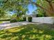 A home's exterior with a well-maintained lawn, mature trees, and a gated driveway at 1701 38Th N St, St Petersburg, FL 33713