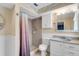 Bathroom with a tile shower, neutral paint, toilet and vanity with white cabinetry at 1739 Woodridge Dr, Clearwater, FL 33756