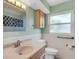 Bathroom with neutral tile, storage cabinet, and large window at 1739 Woodridge Dr, Clearwater, FL 33756