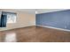 Large bedroom with wood laminate flooring, ceiling fan, and window overlooking front yard at 1739 Woodridge Dr, Clearwater, FL 33756