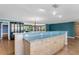 Kitchen featuring a breakfast bar with light wood cabinetry, laminate floors and blue accent wall at 1739 Woodridge Dr, Clearwater, FL 33756