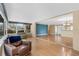 Open living area with laminate floors, large windows, and a blue accent wall at 1739 Woodridge Dr, Clearwater, FL 33756