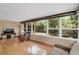 Sun room with many large windows overlooking a shady back yard, laminate floors, and neutral paint at 1739 Woodridge Dr, Clearwater, FL 33756
