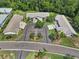 Aerial view of property in a wooded area, featuring a circular driveway and well-maintained landscaping at 1762 Atrium Dr, Sun City Center, FL 33573
