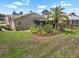Landscaped backyard featuring a screened patio, mature trees, and flowerbeds, offering an ideal setting for relaxation at 1762 Atrium Dr, Sun City Center, FL 33573