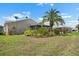 Backyard featuring a well-manicured lawn and tropical landscaping at 1762 Atrium Dr, Sun City Center, FL 33573