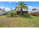 Backyard featuring a well-manicured lawn and tropical landscaping at 1762 Atrium Dr, Sun City Center, FL 33573