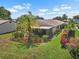 Spacious backyard featuring a screened patio, well-maintained lawn, and mature trees, creating a private outdoor retreat at 1762 Atrium Dr, Sun City Center, FL 33573