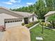 Well-maintained single-Gathering home with a two-car garage, lush landscaping, and a welcoming entrance at 1762 Atrium Dr, Sun City Center, FL 33573