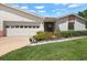 Charming home featuring manicured landscaping, a well-kept lawn, and a two-car garage at 1762 Atrium Dr, Sun City Center, FL 33573
