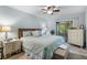 Comfortable main bedroom featuring a ceiling fan, dresser, and side tables at 1762 Atrium Dr, Sun City Center, FL 33573