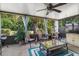 Enclosed sunroom with ceiling fan, comfortable seating, and a view of the lush backyard at 1762 Atrium Dr, Sun City Center, FL 33573