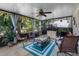 Enclosed sunroom with ceiling fan, comfortable seating, and a view of the lush backyard at 1762 Atrium Dr, Sun City Center, FL 33573