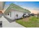 White home exterior featuring a vibrant green roof and well-maintained landscaping at 1802 Bedford Ln # 7, Sun City Center, FL 33573