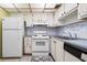 Well-lit kitchen featuring white cabinets and essential appliances at 1802 Bedford Ln # 7, Sun City Center, FL 33573