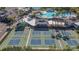 Aerial view of multiple pickleball courts adjacent to a sparkling pool offers various recreational activities for residents at 1802 Bedford Ln # 7, Sun City Center, FL 33573