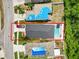 An aerial view of a property with a dark roof, inviting pool, and spacious backyard, framed in a red outline at 18516 Snowdonia Dr, Land O Lakes, FL 34638