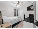 Cozy bedroom with a ceiling fan, tv, and desk set up with white and black decor at 18516 Snowdonia Dr, Land O Lakes, FL 34638
