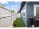 Exterior shot of a grassy side yard with small potted plants at 18516 Snowdonia Dr, Land O Lakes, FL 34638