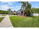 Well-maintained single Gathering home with lush lawn, landscaped garden beds, and tropical palm trees at 18516 Snowdonia Dr, Land O Lakes, FL 34638