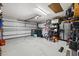 A spacious garage with ample storage, tool racks, a large refrigerator, and a bright overhead light at 18516 Snowdonia Dr, Land O Lakes, FL 34638