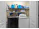 Laundry room with modern washer and dryer units, shelving, and ample storage space at 18516 Snowdonia Dr, Land O Lakes, FL 34638