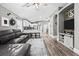 Open living space with a gray sofa, modern kitchen with an island, hardwood floors and natural light at 18516 Snowdonia Dr, Land O Lakes, FL 34638