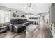 Open-concept living room with a gray sectional sofa, kitchen, and dining area, perfect for entertaining at 18516 Snowdonia Dr, Land O Lakes, FL 34638
