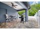 Covered patio area with ceiling fan, seating, and an outdoor grill at 18516 Snowdonia Dr, Land O Lakes, FL 34638