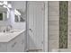 Well-lit bathroom with marble-look tiles, modern fixtures, and shower with mosaic accent stripe at 1877 Pine Cone Cir, Clearwater, FL 33760
