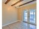 Bright dining room featuring tiled floors, decorative ceiling beams, and glass patio doors at 1877 Pine Cone Cir, Clearwater, FL 33760