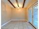 Bright dining room featuring tiled floors, decorative ceiling beams, and glass patio doors at 1877 Pine Cone Cir, Clearwater, FL 33760