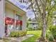 Condo exterior showcasing the front entrance, lawn, and landscaping in a well-maintained neighborhood at 1877 Pine Cone Cir, Clearwater, FL 33760