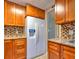 This kitchen features wooden cabinets, stainless steel appliances, and an eye-catching backsplash at 1877 Pine Cone Cir, Clearwater, FL 33760