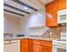 Kitchen with wooden beams, stainless steel appliances, and a mosaic backsplash at 1877 Pine Cone Cir, Clearwater, FL 33760