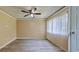 Living room with new gray floors, ceiling fan, and a doorway to the exterior at 1877 Pine Cone Cir, Clearwater, FL 33760